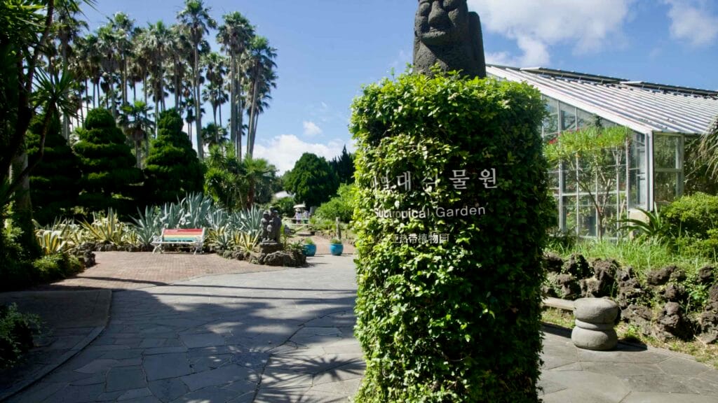 Ivy-clad Subtropical Garden sign near a greenhouse at Hallim Park.