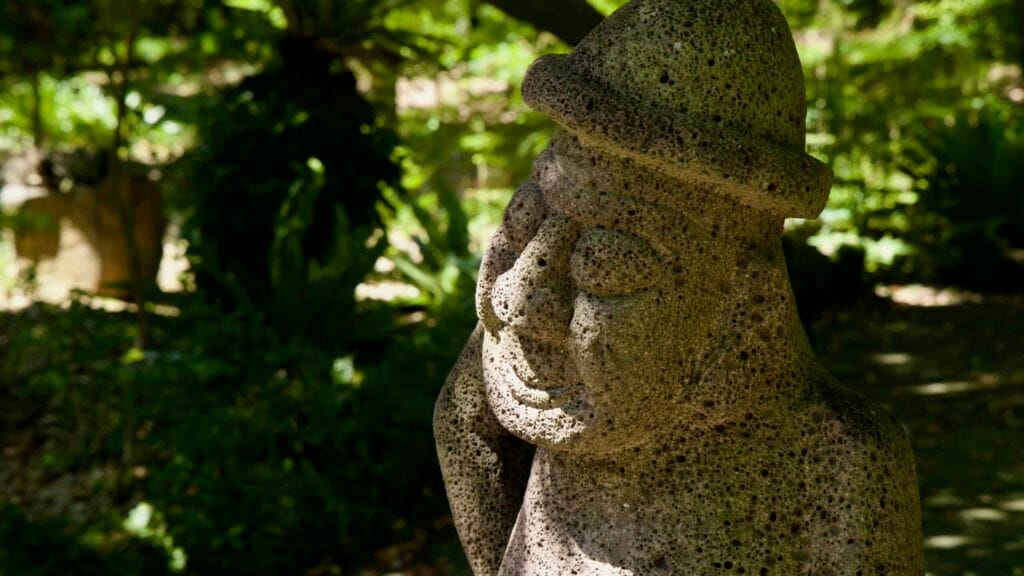 Close detail of a dol hareubang’s face in deep shade.