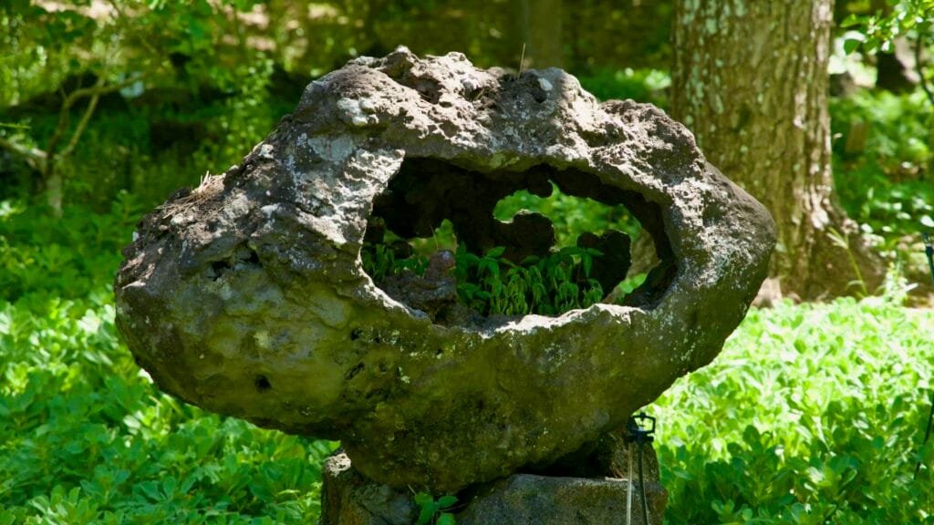 Weathered lava stone sculpture with hollow at Hallim Park.