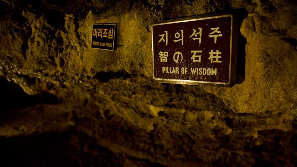 ‘Pillar of Wisdom’ and ‘Watch your head’ plaques on a wall in the Hallim Park cave.
