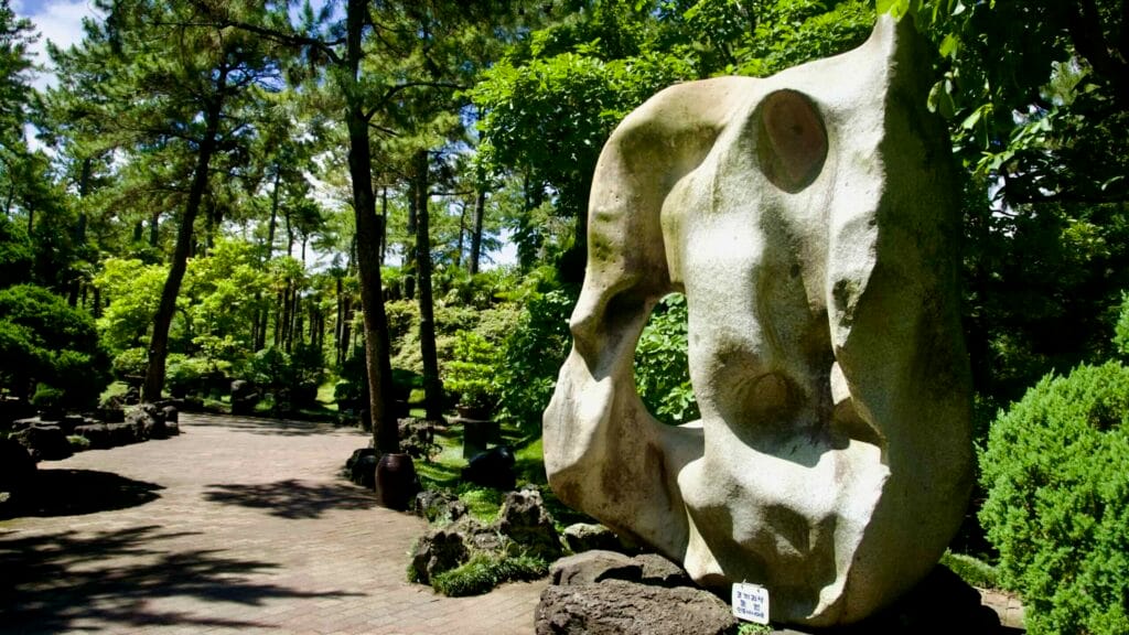 Abstract stone sculpture beside a shaded path in Hallim Park’s gardens on Jeju.