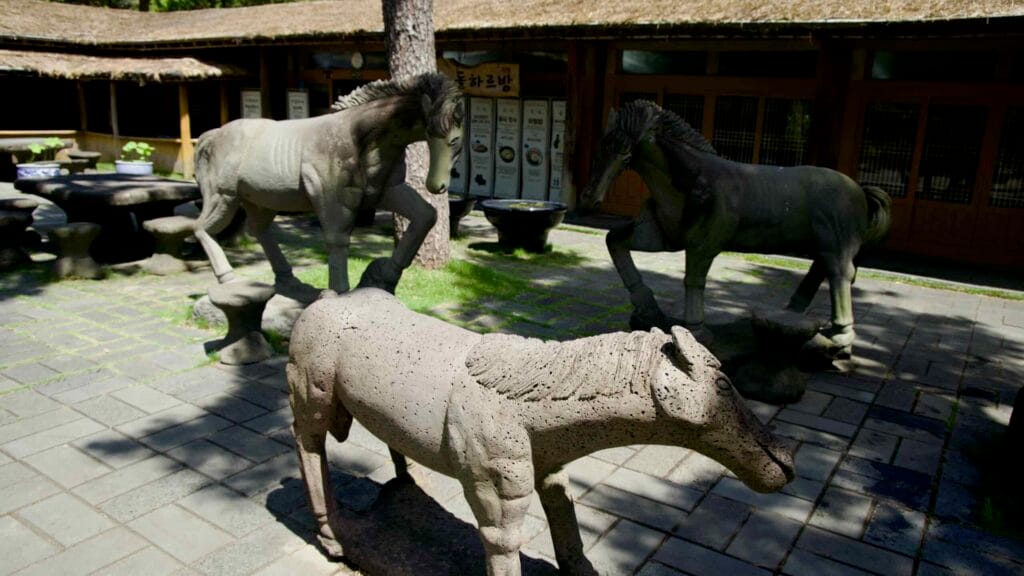 Close view of carved stone horses in Hallim Park’s folk village.