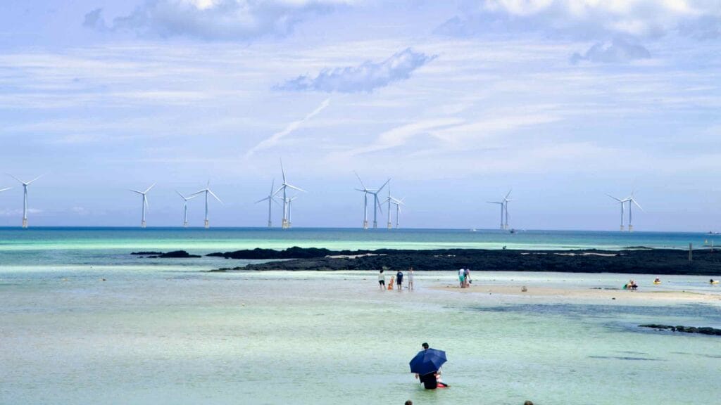 Wind turbines beyond Geumneung’s tidal flats and lava rock.