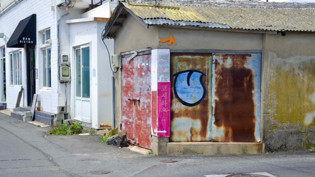 Rusted door and pink alley sign near Geumneung Port.
