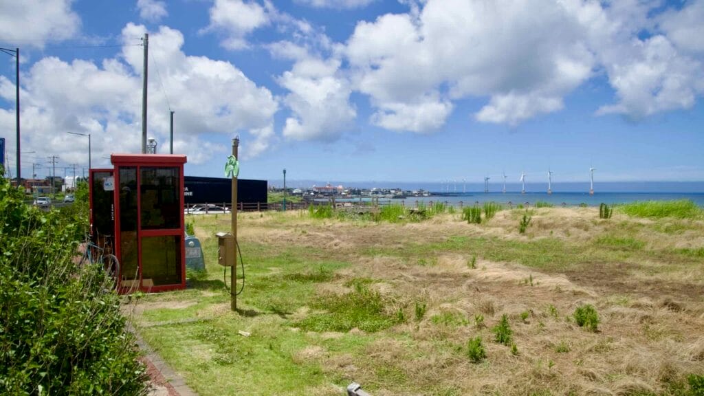 Red bike shelter with offshore wind farm in the distance.