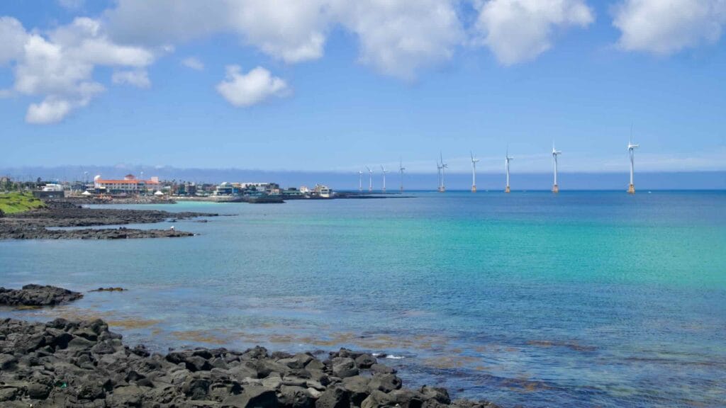 Basalt shore curving toward Sinchang Port and wind farm.