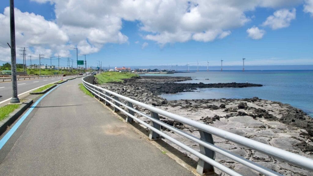 Blue‑lined bikeway along the coastal highway toward Sinchang.
