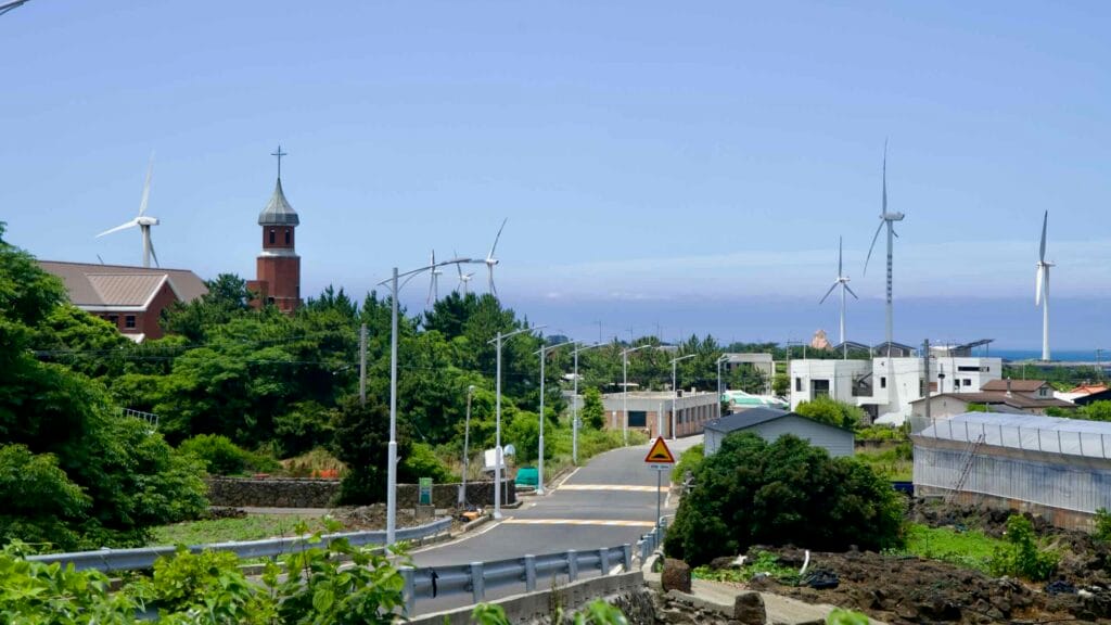 Sinchang village with church tower and wind turbines along the coast.