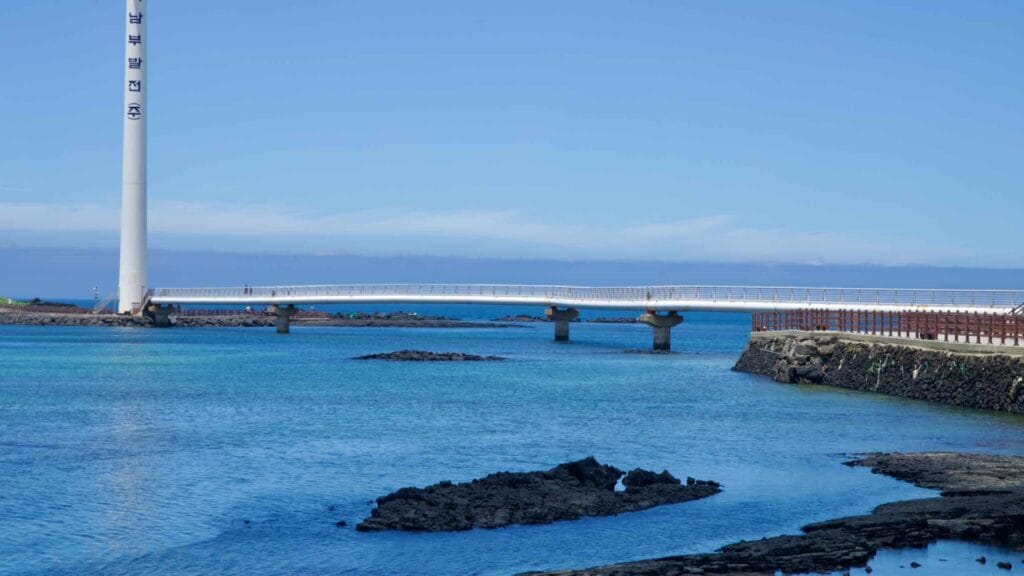 Pedestrian bridge spans the inlet at Sinchang Windmill Coastal Road.