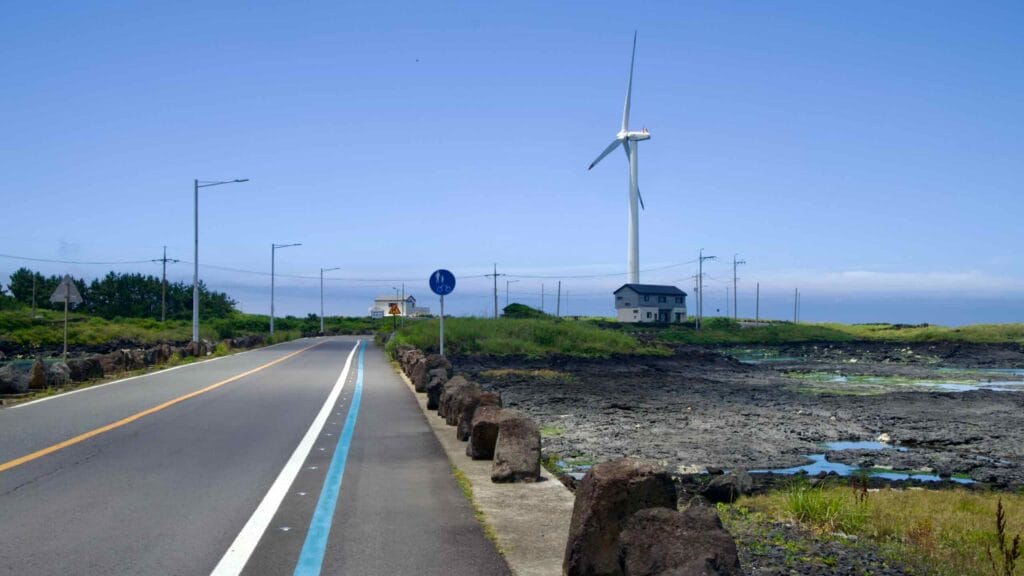 Coastal road and bike lane leading toward a turbine at Sinchang.