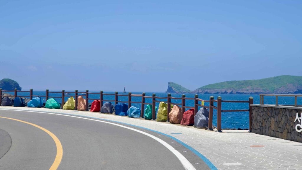 Painted shoreline boulders as the road curves toward Chagwido.