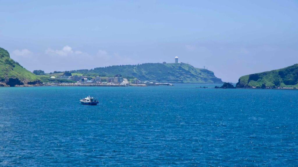 Tour boat below Suwolbong’s cliffs and radar dome.