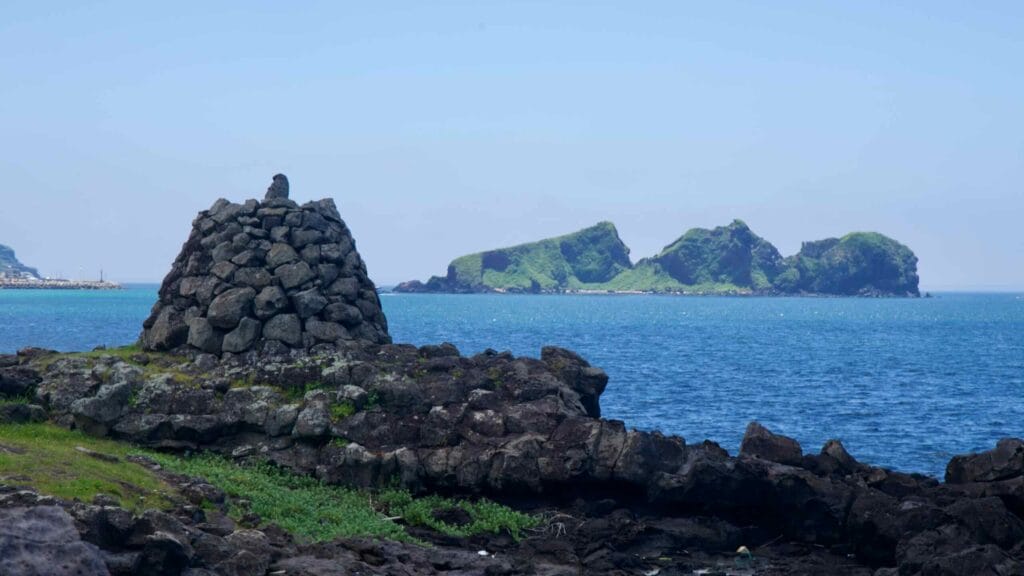 Stone cairn on basalt ledges with Chagwido beyond.