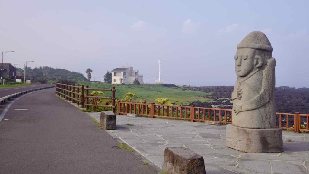 Jeju dolhareubang statue watching over the Sagye coastline promenade.
