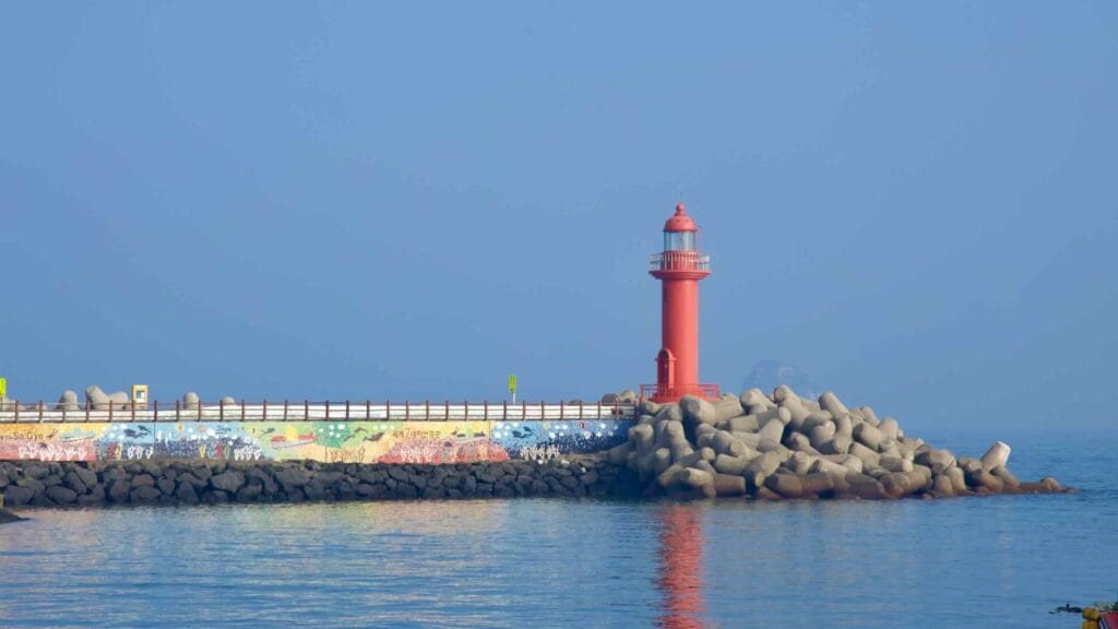 Close view of Sagye’s red lighthouse and mural seawall.