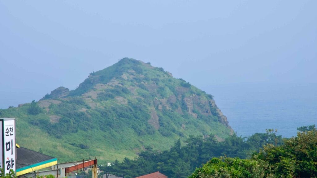 Traditional halls of Bomunsa perch amid pines at the base of Sanbang Mountain’s steep lava walls.