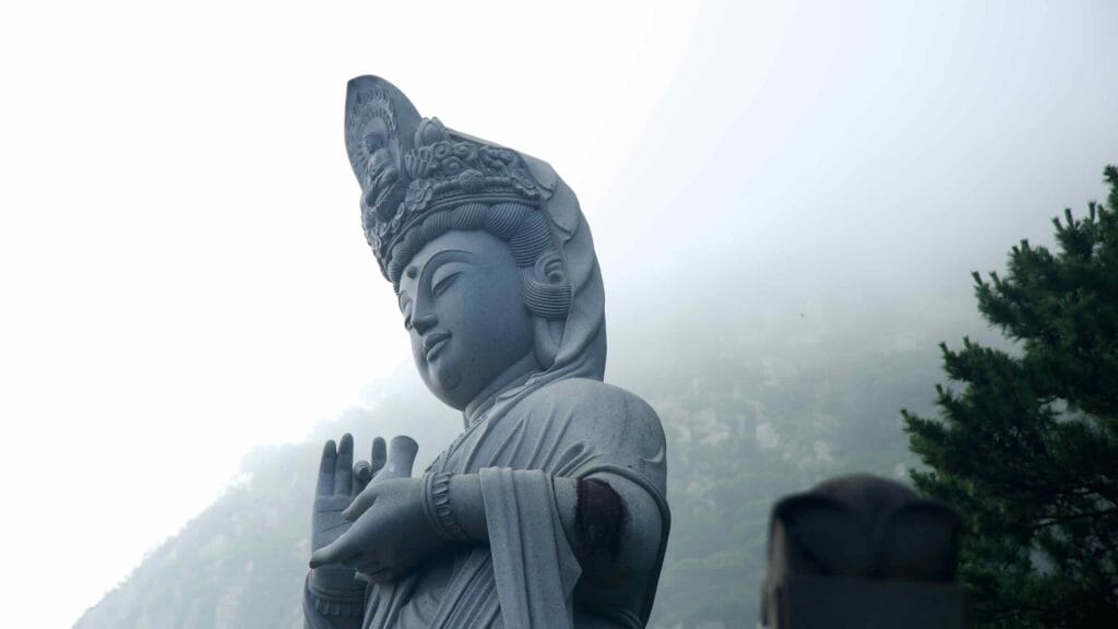 Close Bodhisattva portrait at Bomunsa as fog slides over Sanbangsan.