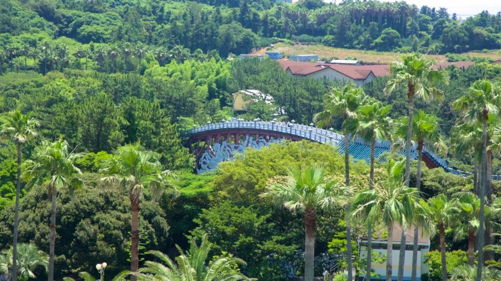 Seonim Bridge peeks through trees near Cheonjeyeon Falls.