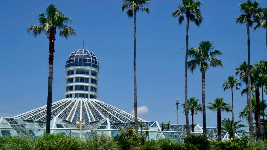 Yeomiji Botanical Garden’s dome and glass roof framed by tall palms.