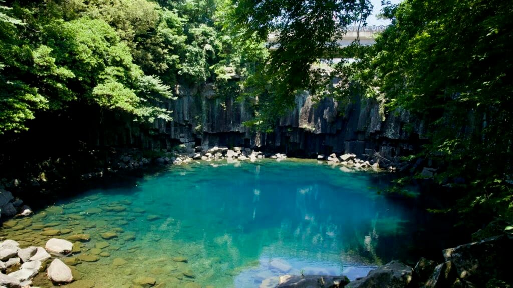 Emerald pool and columnar basalt cliffs at Cheonjeyeon, bridge above.
