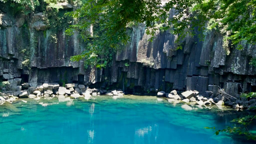 Columnar basalt walls meet a turquoise pool at Cheonjeyeon’s first area.
