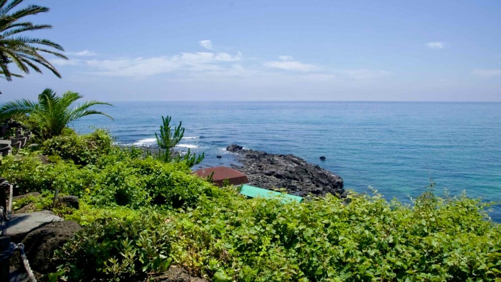 Coastal view over lava rocks and clear blue water at Jungmun.