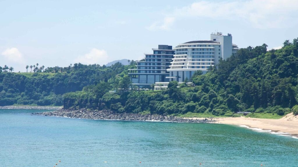 Basalt dolhareubang and surfboard outside The Cliff at Jungmun.