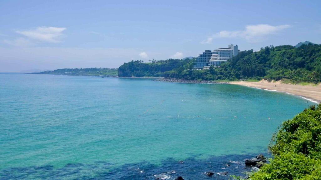 Headland hotels overlook Jungmun Saekdal Beach and turquoise water.
