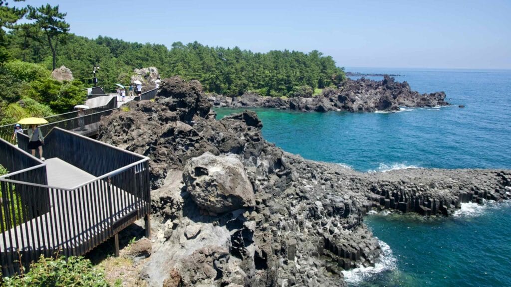 Tourists stroll along elevated paths above Jusangjeolli Cliffs.