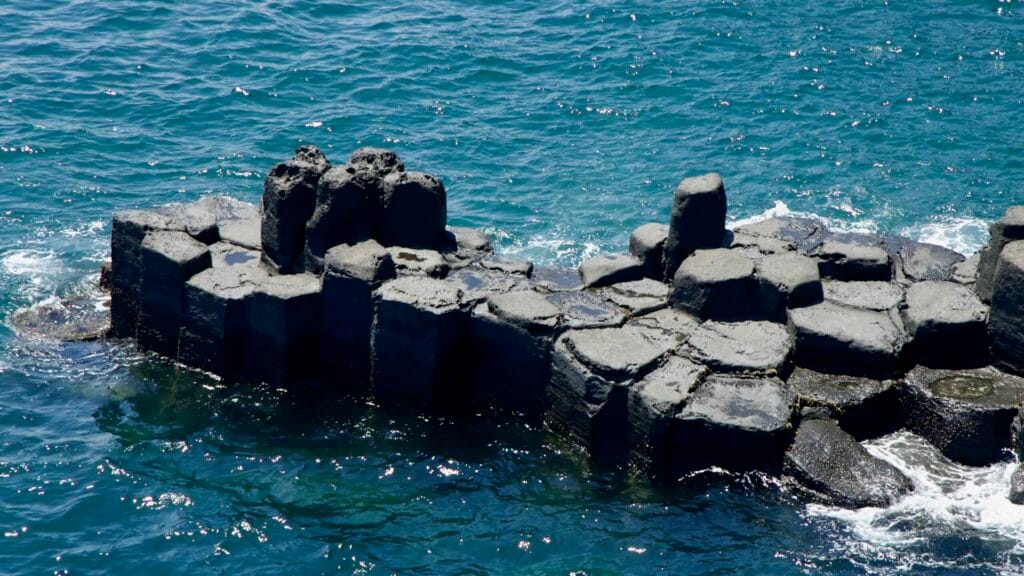 Isolated basalt outcrop in the sea at Jusangjeolli Cliffs.
