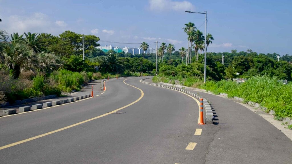 Palm trees line a road leading toward apartments near Beophwan.