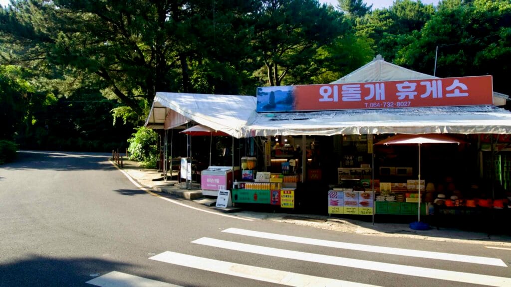 A small roadside snack shop marks the entrance to the Oedolgae Rock trail in Seogwipo.