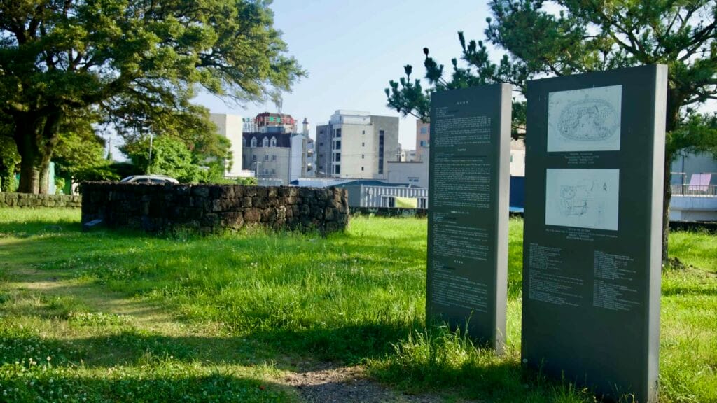 Panels and basalt walls outline the Seogwi Fortress site in downtown Seogwipo.