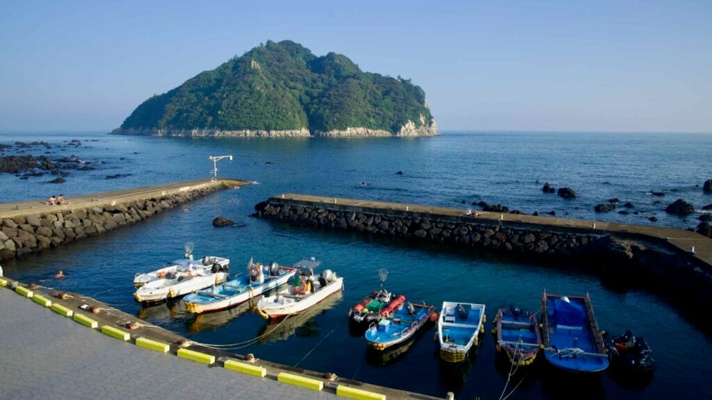 Skiffs rest inside the breakwater as Seopseom Island rises offshore.