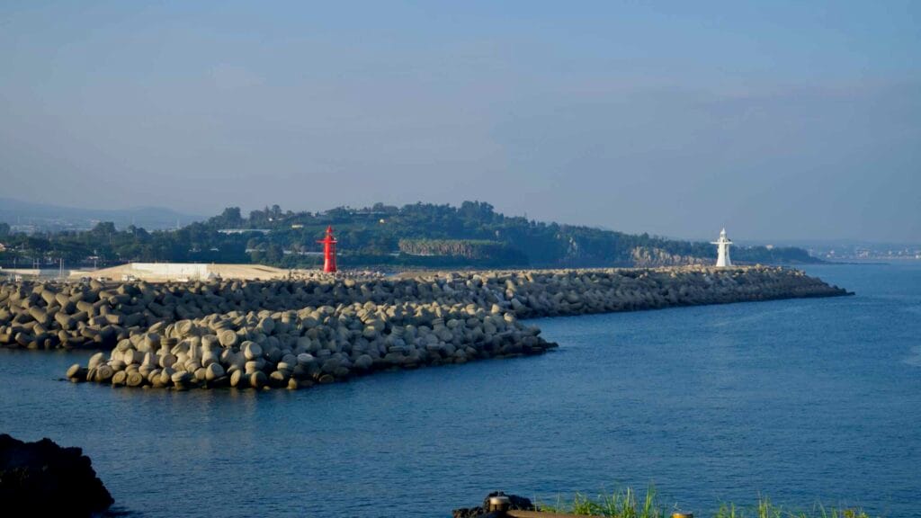 Red and white lighthouses stand on breakwaters guarding Hahyo Port.