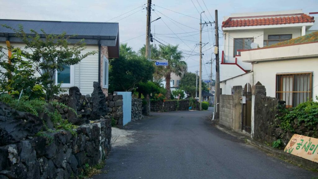 A quiet basalt‑walled lane winds through homes near Mangjang Port.