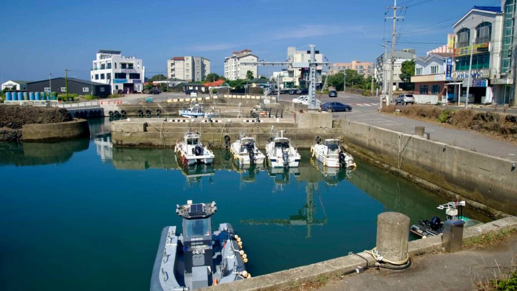 Fishing boats and quay cranes line the harbor basin at Namwon Port.