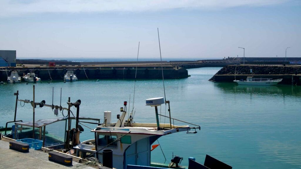 Fishing boats rest on calm water inside the protected basin at Taeheung harbor.