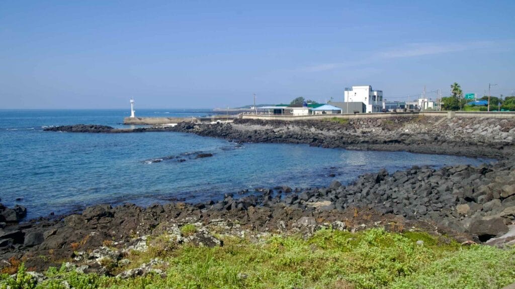 A rocky cove and white beacon sit near Shiheung-ri on Jeju’s south coast.