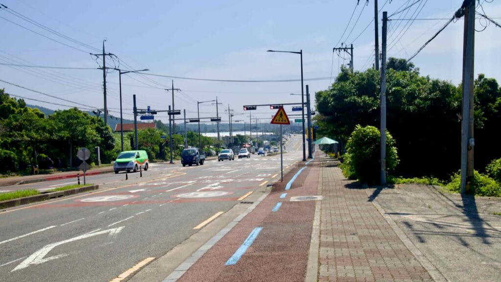 The Il-ju Road corridor climbs toward a crest in Namwon with a bike lane, signals, and light traffic.