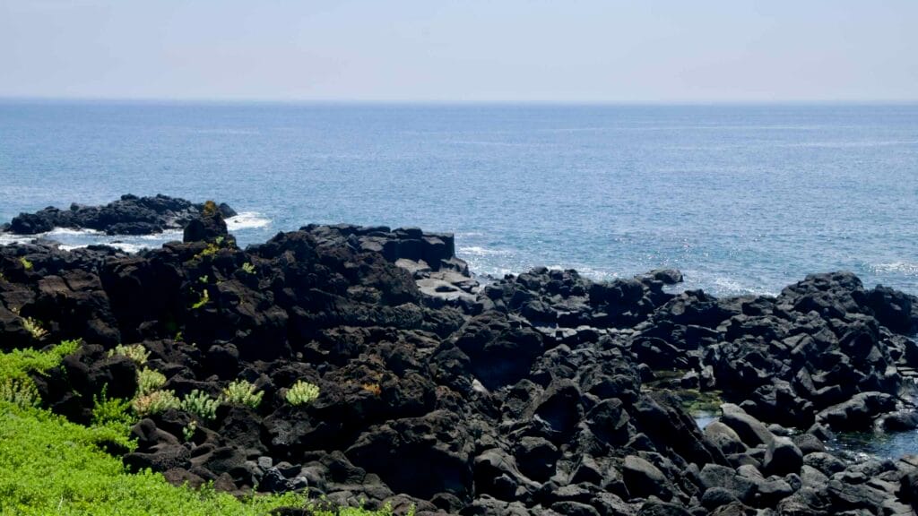 Basalt rocks at White Hill on the Pyoseon coast with open sea views.