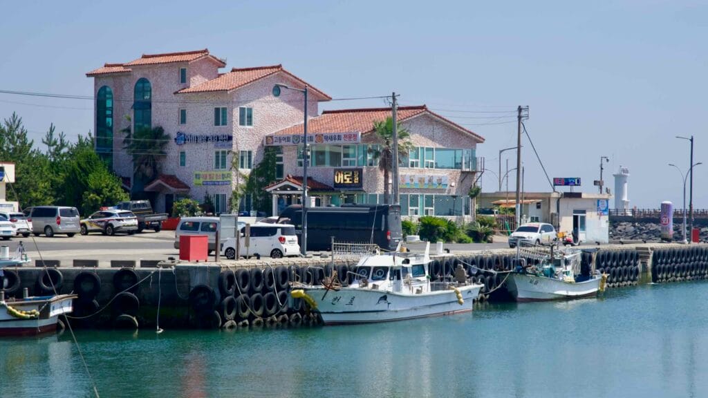 Fishing boats moor along a tire‑lined quay at Pyoseon Port.