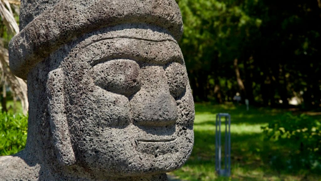 Close-up of the basalt face of a Jeju dolhareubang near Pyoseon Beach shows pitted stone.