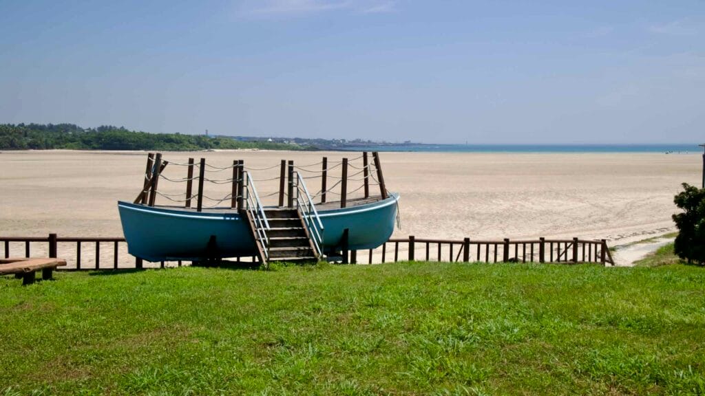 From a rise, the viewing deck and broad sand flats of Pyoseon Beach stretch toward the water.