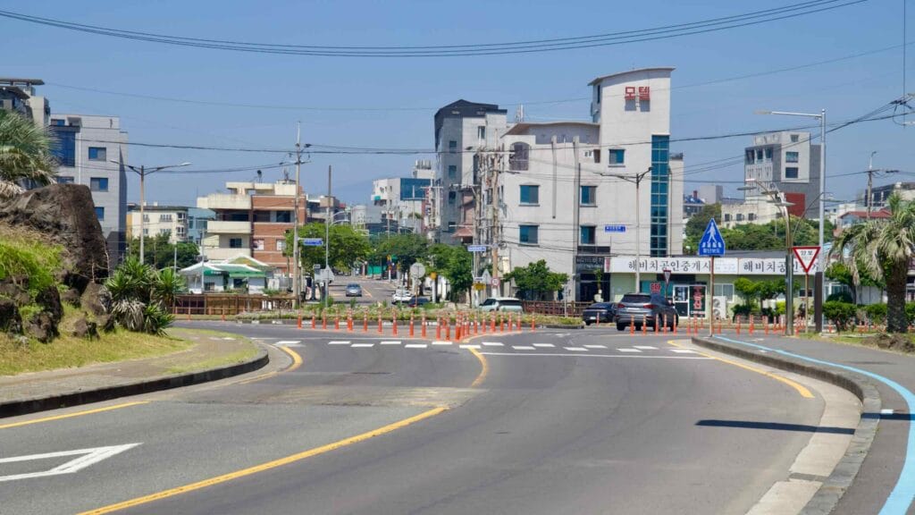 A curved street leads into Pyoseon town center near the beach.