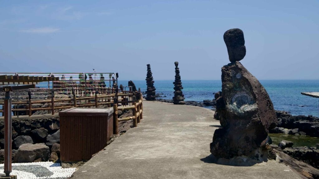 Stone stacks and sculptures greet walkers on a coastal path.