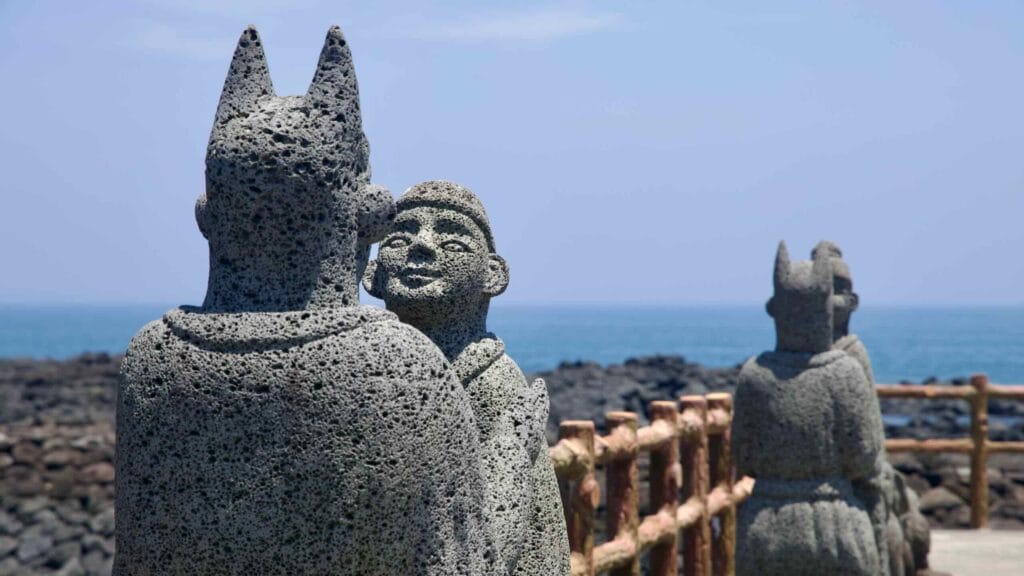 Close basalt statues stand along the waterfront pier.