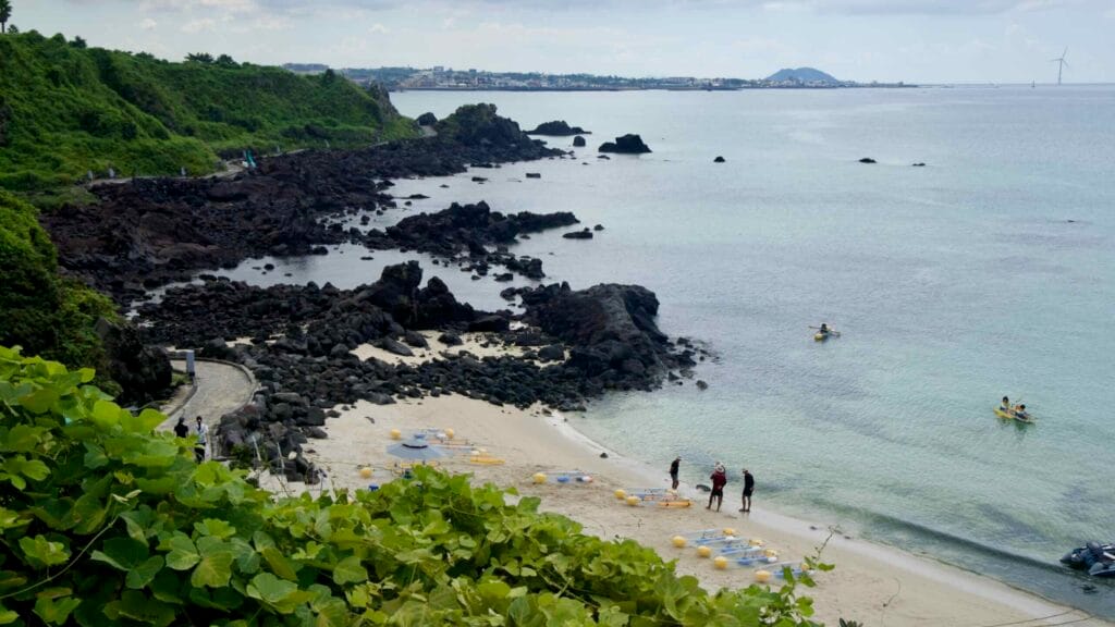 Kayakers pass basalt pinnacles off Handam’s pale sand cove.