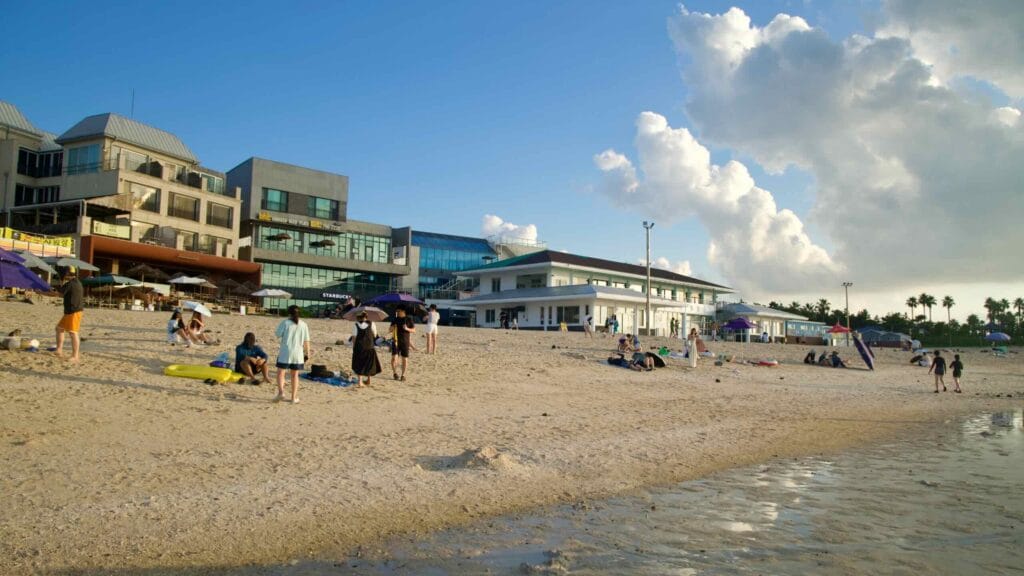 Hyupjae Beach with cafés and visitors along the shore.