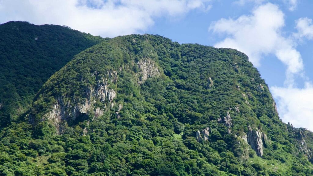 Mountain cliffs rise near the Jeju Aerospace Museum on Jeju Island.